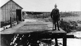 Frihedsbroen med tysk grænsegendarm, 1914. For at ingen skal krydse broen illegalt, er en del broplanker blevet fjernet.  Foto: Vejen Lokalhistoriske Arkiv.